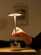 Hand Touching Top Disc to Operate Modern Cordless Table Lamp