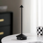 Verve black cordless desk lamp placed on modern white table beside home decor accessories