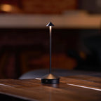 Dark bronze Verve wireless lamp sitting on open book reading nook interior shot